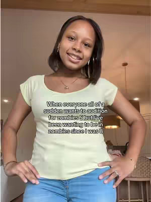 A woman in a light yellow t-shirt and blue jeans stands in front of a light-colored wall with hands on hips, smiling at the camera, with text overlaid on the image.