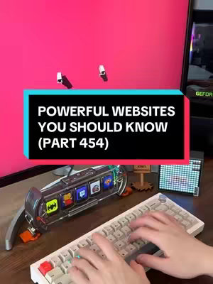 The image shows a person’s hands typing on a white mechanical keyboard, centered towards the bottom of the frame. Above the keyboard and hands, there's an illuminated transparent device showcasing several app icons. The background is a bright pink wall with two small, off-white lamps.