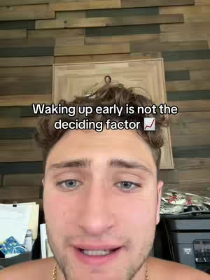 A selfie of a man with short, brown curly hair, light-colored eyes, and a slight smile. He's in front of a wooden wall, and text overlays are added to the image.