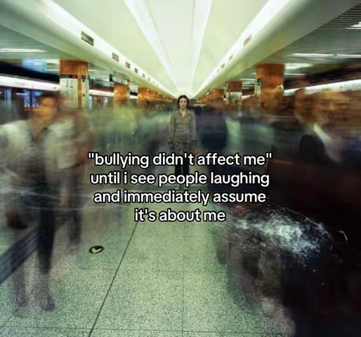 A woman stands in a subway or train station, the background and other figures are blurred to create a sense of motion. Text overlayed on the image reads, "bullying didn't affect me" until i see people laughing and immediately assume it's about me". The image has an overall cool color palette.