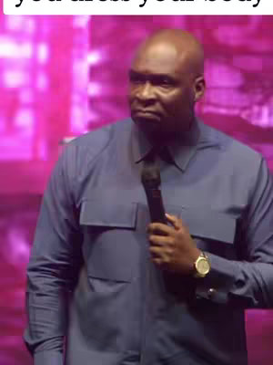The cover image shows a man in a blue shirt holding a microphone. He is looking slightly off-camera. The background is a blurry pink and purple.