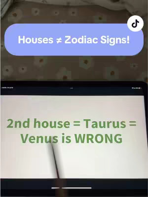 An overhead shot shows a tablet displaying astrological information. A speech bubble with the text "Houses ≠ Zodiac Signs!" is layered at the top. The tablet screen shows the text "2nd house = Taurus = Venus is WRONG" in green against a white background. The image has a casual, informal setting.