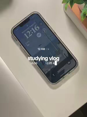A top-down shot of iPhone screen displaying the time as 12:16 on a blue wallpaper with Spotify icon.