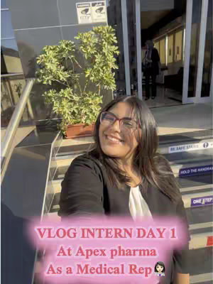 The cover image features a young woman smiling at the camera. She wears glasses, a black blazer, and a white top. In the background, there's a building with steps and a sign. Text overlays add context, like 'VLOG INTERN DAY 1' and 'At Apex pharma.'