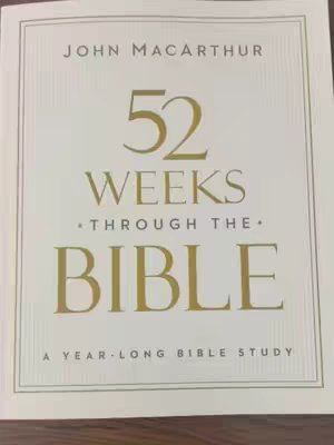 The cover image shows a book with a cream-colored background and text in various shades of gold. The title reads "52 WEEKS THROUGH THE BIBLE," with the author's name, John MacArthur, at the top. Below the title is the subtitle "A YEAR-LONG BIBLE STUDY." The layout is clean and professional, with a framed border.