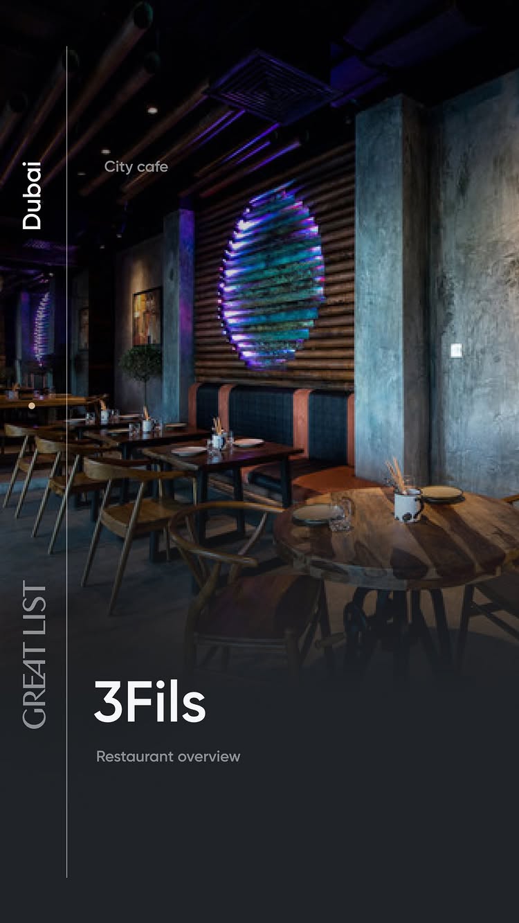 Image showcases the interior of a modern restaurant, featuring dark, sleek decor with wooden tables and chairs. A large, illuminated circular design on the back wall serves as a focal point. The restaurant appears well-lit, with a sophisticated ambiance. Text overlays include 'Dubai' and 'City cafe' vertically and horizontally. The brand name '3Fils' is prominently displayed.