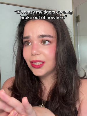 A woman with long dark hair and red lipstick looks at the camera with an expression of slight surprise or concern. Text is overlaid at the top of the image. She has blush applied to her cheeks.