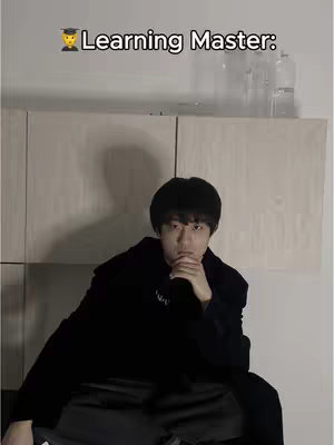 The cover image shows a young man with black hair sitting in what looks like a room, and a caption is overlayed at the top. The room has light-colored wood paneling on the wall. The person is wearing a black outfit and resting his hand on his chin with his other arm supporting the elbow. The lighting appears to be coming from the left, creating shadows and highlighting the person's face. The overall composition is well-lit, and the focus is clearly on the person and the text.
