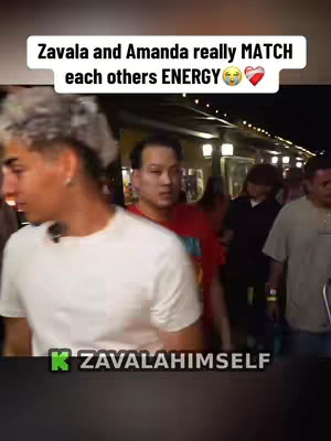 An outdoor shot, potentially at night, with three figures in the foreground. On the left, a light-skinned male with light-colored hair is visible. In the center, a person of Asian descent is seen, and on the right, another person of light skin is partially visible. The lighting appears to be from streetlights. There is text at the top, and a brand logo overlaid at the bottom of the image.