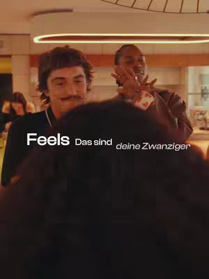 The cover image has two men, an interior setting. Text overlays are in white. The person in the foreground has a dark shirt. The person in the background is wearing a brown jacket. The image has a warm color palette.