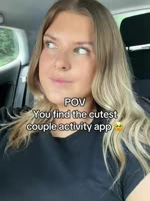A woman with long blonde hair sits in a car, looking to the side with a slight smile. Text overlays are present. The background suggests a daytime setting.