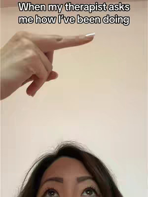 The image features a partial view of a person looking upward with a hand positioned above, pointing towards an invisible point. The background is a plain, light-colored wall.