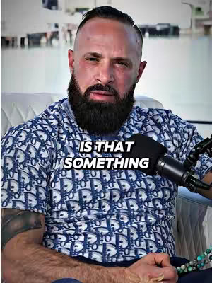 The cover photo features a man in a blue patterned shirt, seated in a white chair with a microphone in front of him. Text overlaid on the image poses a question: "IS THAT SOMETHING". The background suggests an outdoor setting, possibly near water, adding a touch of brightness.
