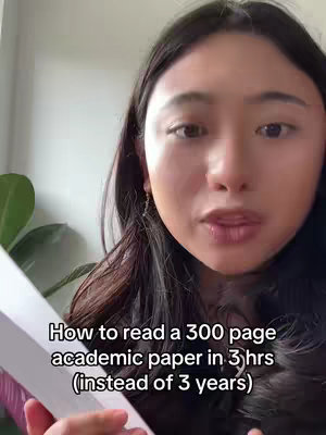 A woman with dark hair looks towards the camera, holding a book. Text overlay in white font appears below her face.