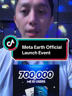 A man is centered in the frame, looking directly into the camera. The background is minimally visible behind him. Overlayed partially on his face is a rectangular graphic with the text "Meta Earth Official Launch Event". Underneath this, the bottom two-thirds of a poster is visible with the numbers "700,000" displayed prominently, along with the text "ME ID USERS" and the Meta Earth logo along with images of ID cards. A TikTok logo is in the top corner of the image.