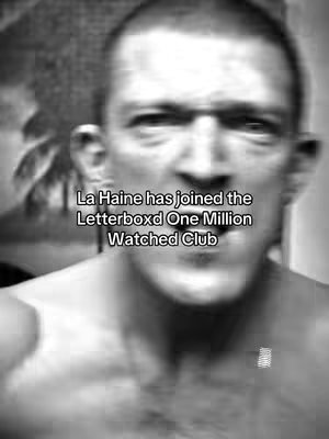 The cover image is a slightly blurred, black and white close-up of a man's face. The man is looking towards the camera, his expression is neutral. The image is softly lit. Text overlayed on the image says 'La Haine has joined the Letterboxd One Million Watched Club'.
