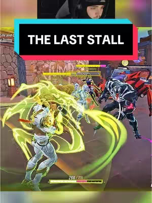 The cover image features a split-screen. The top half shows a streamer in a headset looking at a gameplay screen. The bottom half of the image displays a colorful action scene from a video game featuring multiple characters and combat effects. Text overlayed says "THE LAST STALL".
