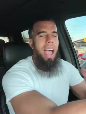 The cover image shows a man inside a car, with a focused expression, mouth open. The background suggests a street scene, implied by the car's interior and visible outside elements. The man has a dark beard and is wearing a white shirt.
