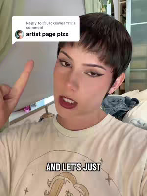 A close-up shot of a person with short dark hair and bold makeup, pointing a finger up. They are wearing a light-colored t-shirt. A text bubble from a comment is visible above them, and additional text is placed at the bottom of the frame