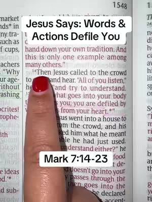 A close-up shot features a woman's hand pointing with a red-polished index finger at a Bible page. Above the finger, text in a white box reads, 'Jesus Says: Words & Actions Defile You.' Below, in a separate white box, the text 'Mark 7:14-23' is displayed. The page is open to a section of text with visible lines and passages. The color scheme includes off-white paper, black text, and the red nail polish.