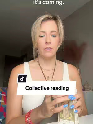 A woman with blonde hair and a white tank top is holding a stack of Tarot cards. The image is framed from the waist up, with her hands prominently featured.  A banner labeled 'Collective reading' is overlaid on the image. Additional text that reads 'it's coming' is in the upper left of the image. The background suggests an interior setting.