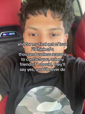 A selfie-style shot of a young man seated in a car. The background shows a red interior. The man is looking at the camera. Text overlays are positioned over his image.