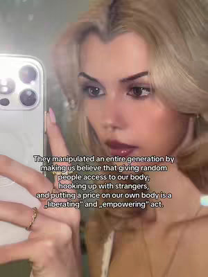 A selfie-style video with a woman holding a phone, appearing to take the shot, with text overlay on the lower section of the screen.