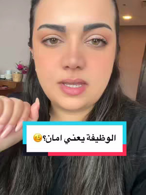 A woman with dark hair and a light complexion is centered in the frame. She is looking at the camera. Overlaid on the video is a rectangular text box in a light blue color, white frame at the bottom of the screen. The text in Arabic is in white. The background of the video appears to be a dimly lit room with hints of objects in the background.