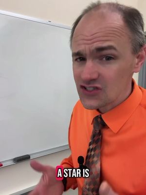 A medium shot shows a man in an orange shirt and patterned tie, with text overlayed at the bottom. He is facing the camera and talking.