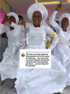 A group of women in white robes and head coverings dancing, with one in the center smiling and looking at the camera. A speech bubble is visible in the image.
