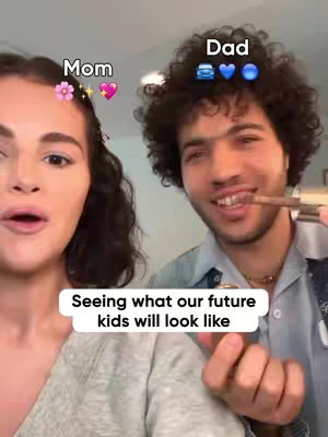 The cover image shows a woman on the left and a man on the right, slightly out of focus, with text that says, "Seeing what our future kids will look like?" The woman is fair-skinned and wearing makeup, looking at the center of the frame with her mouth slightly open. The man has light brown skin, dark curly hair, and is holding a makeup brush up to his face while smiling. Above their heads the word Mom and Dad are written, Mom is decorated with floral and heart emojis and Dad with emojis of a car, heart, and blue circle. The background is blurred.