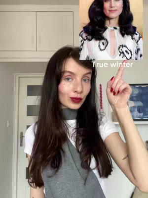 A woman with long dark hair is pointing upwards with her right index finger. Behind her is a photo of actress. Below the photo, the text "True winter" is displayed. The woman is wearing a white t-shirt.