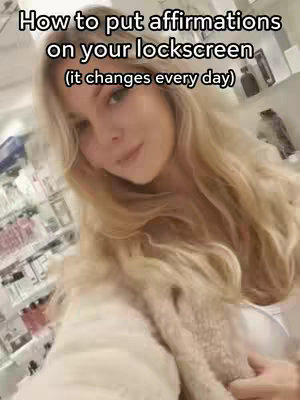 A woman with long blonde hair looks at the camera at a slight angle. Text overlayed on the image at the top says "How to put affirmations on your lockscreen (it changes every day)".  The background is blurred but appears to have various product displays.