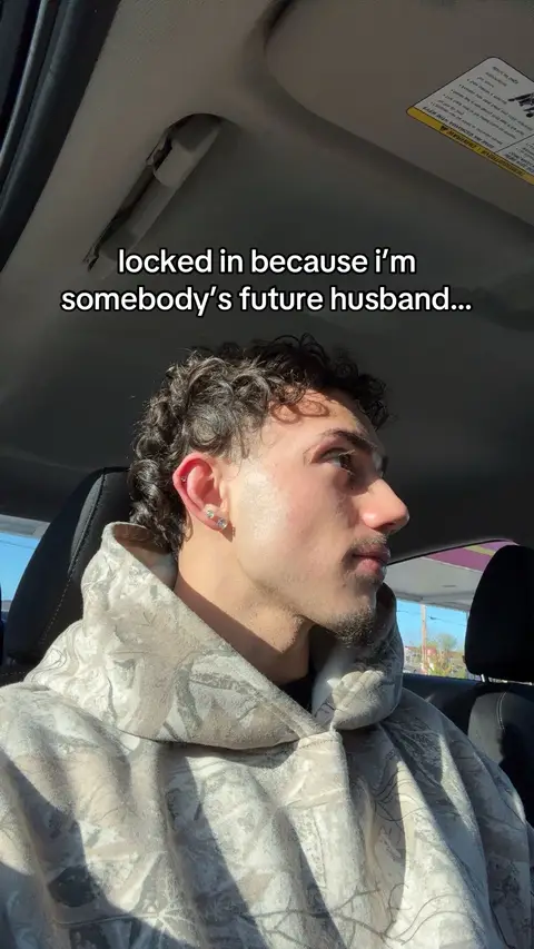 A man, presumably the creator, is seated in the driver's seat of a vehicle. The image has a natural daylight, with the individual looking to the side, away from the camera. Overlaid text suggests this could be a video about relationships or personal identity.