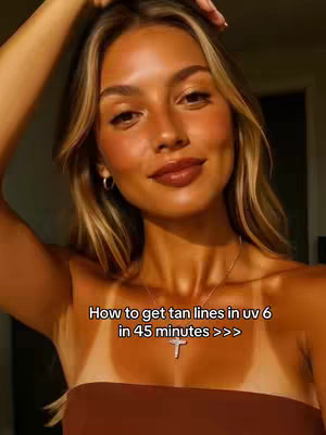A woman with long blonde hair, tan skin, and a brown tube top is the focus. She is smiling, and one arm is raised slightly towards her head. Text overlayed is present at the bottom of the frame.