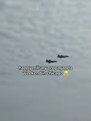 Two fighter jets fly in the cloudy sky with overlay text. The overall composition is simple, focusing on the jets and the sky.