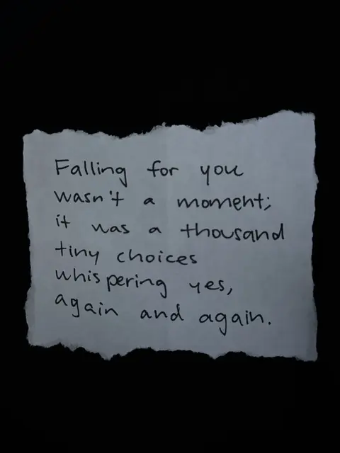 A piece of white paper with torn edges against a black background. Handwritten text in black ink is centered on the paper, conveying a romantic message.