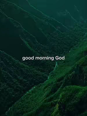 The image displays a natural landscape of green, textured mountains. Overlayed in the center is the text 'good morning God' in white.