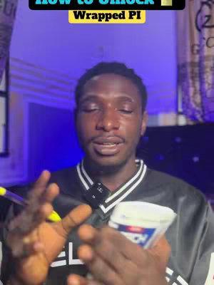 A man with short, dark hair and a black shirt with white stripes is in a room with purple lighting and what appears to be a Gucci tapestry on the wall behind him. He is holding up a container and gesturing with his hands while facing the camera.