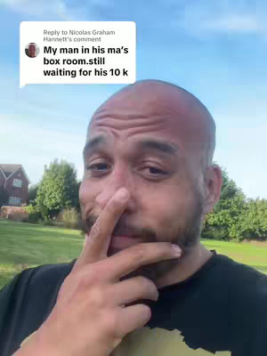 A man with a shaved head and a beard looks at the camera with a slightly awkward expression, touching his nose with his finger. A text overlay appears in a speech bubble above his head, extracted from his comment.