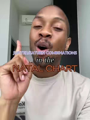 A selfie-style video cover image features a Black man with short hair and a light-colored shirt, pointing upward with his right index finger while slightly opening his mouth. Text overlays are displayed above and below the man, with the top text in purple and the bottom text in orange. The background is a blurred interior setting, with a glimpse of an air conditioning unit visible.