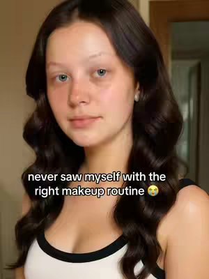 The cover image features a young woman with dark wavy hair and fair skin. She is looking at the camera with a neutral expression. She is wearing a black and white top. The text overlay says 'never saw myself with the right makeup routine' with a shocked face emoji.