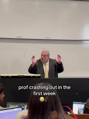 A college lecture hall with a professor speaking at the front, hands raised.  Students are visible in the foreground. The hook is overlaid near the bottom.