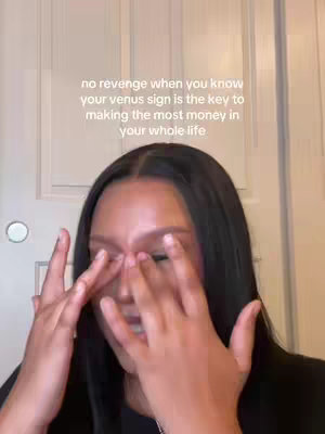 The cover image features a woman with long, dark hair, partially visible in a close-up shot. She is touching her face with her hands, and the text overlayed suggests a message related to astrology and finances.