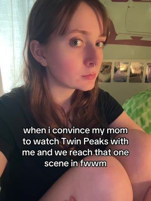 A selfie-style shot featuring a person with fair skin and auburn hair gazing intently at the camera. The background is somewhat obscured but hints at a domestic setting, possibly a bedroom or living space, with decorative elements and visible light. The text overlay at the bottom of the screen describes the situation.