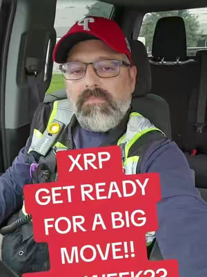 A man in a red baseball cap with a Philly logo is sitting in the driver's seat of a car. He wears glasses and has a beard. There's a brightly colored reflective vest. The graphic of a sign is placed over him that says, "XRP GET READY FOR A BIG MOVE!! WEEK??"