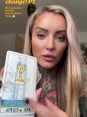 A woman with blonde hair is holding a tarot card. Text overlays are present in the upper-left corner. The background is softly lit.