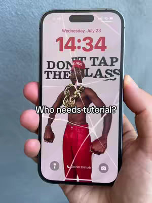 A smartphone screen displays a wallpaper featuring a man wearing a gold chain and a red hat, set against a pale, neutral background. The screen is visibly cracked, suggesting damage. Overlayed text in a clear font reads 'DON'T TAP THE GLASS'. Additional text at the bottom asks, 'Who needs tutorial?'