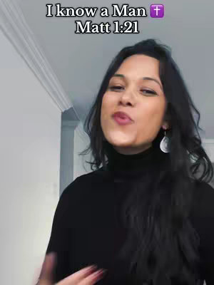 A woman with dark hair and a black turtleneck smiles slightly at the camera. Text overlayed on top reads 'I know a man' and 'Matt 1:21'. In the background is a white wall and a part of a doorway.