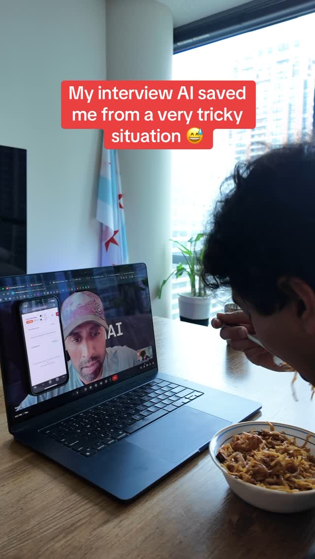 The cover image shows a man preparing to eat noodles in a bowl, while a laptop on the table displays a video call. A smartphone shows the video call on a separate screen. On the laptop, the person on the call screen has a green backdrop with the letter "AI" in white. The background is a bright apartment setting with the Chicago flag. The text overlayed on the cover image reads, 'My interview AI saved me from a very tricky situation'.